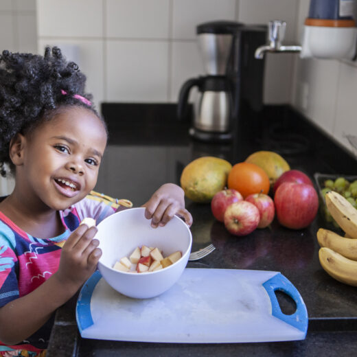 little girl eating apple slices.